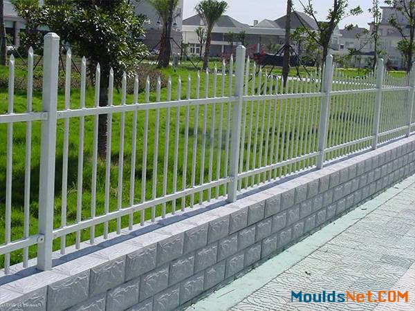 Gray ornamental steel tubular fence with wavy spear top.