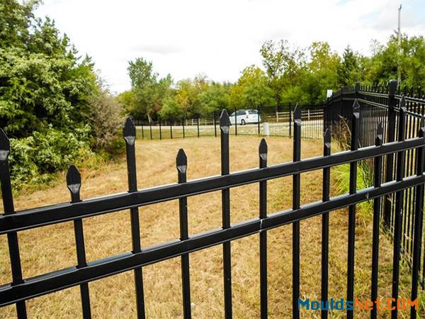 Black ornamental steel tubular fence with staggered spear top.